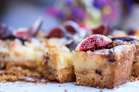 Close up view of sliced fig pie over multicolor flower backgroundの写真素材
