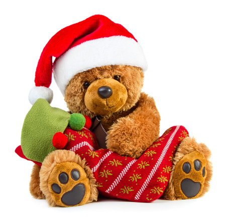 Teddy bear wearing a santa hat with christmas stocking isolated on white backgroundの写真素材