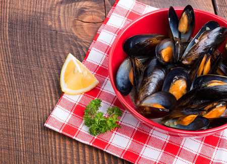 Prepared mussels with lemon and parsley on wooden tableの写真素材