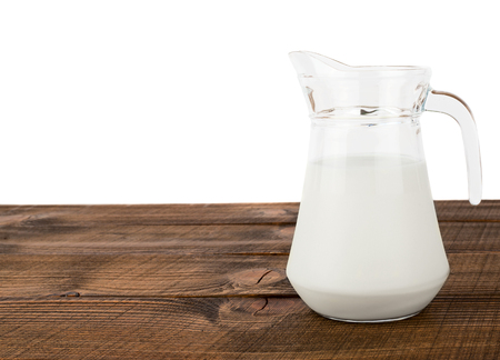 Fresh white milk in glass jar on brown wooden background with white isolated copy spaceの写真素材