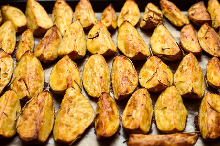 Close up view of potatoes slices on oven pan after cookingの写真素材