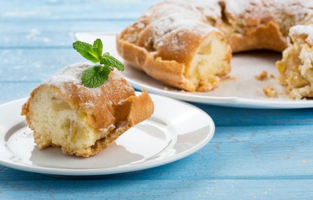 Sliced apple cake on plate, blue wooden backgroundの写真素材