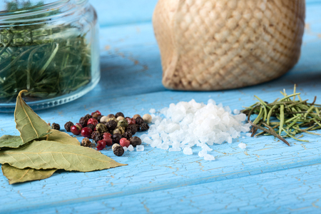 Sea salt, pepper and dry rosemary on blue wooden backgroundの写真素材