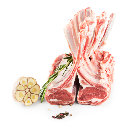 Racks of lamb, ready for cooking, with fresh rosemary, garlick, pepper isolated on white backgroundの写真素材