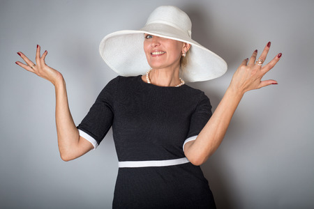 Pretty aged woman with white hat over grey backgroundの写真素材
