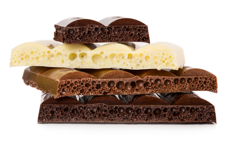 Dark, milk and white porous chocolate isolated on white backgroundの写真素材