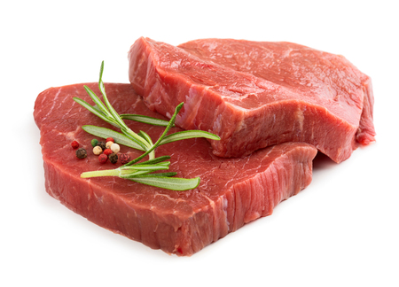 Two raw beef steaks with rosemary isolated on white backgroundの写真素材