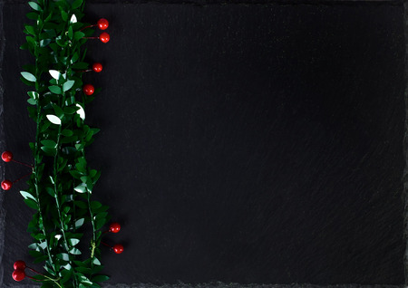 Christmas black background with holly berryの写真素材