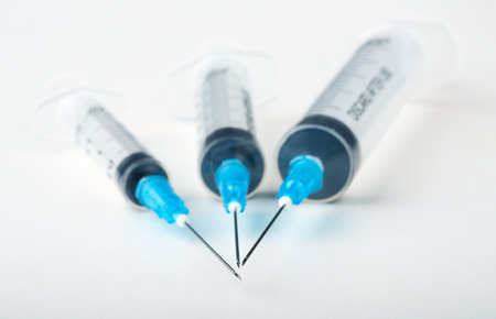 Three plastic syringes on white backgroundの写真素材
