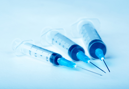 Three plastic syringe on blue backgroundの写真素材