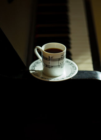 Coffee cup with musical notation on piano, close up view with sunshineの写真素材