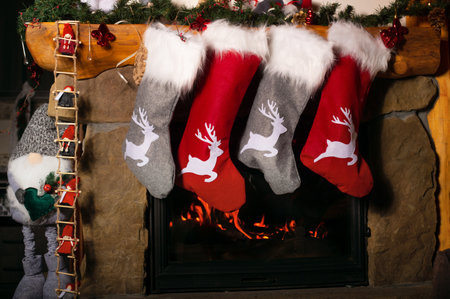 Closeup photo of christmas socks hanging on burning fireplaceの写真素材