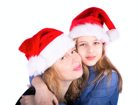 Happy mother and daughter in santa hats over white backgroundの写真素材