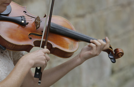 Violinist playing classical music with violin on the streetの写真素材