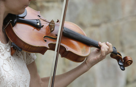 Violinist playing classical music with violin on the streetの写真素材