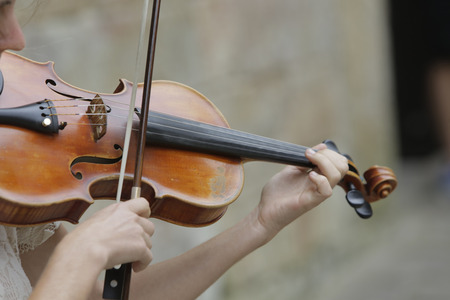 Violinist playing classical music with violin on the streetの写真素材