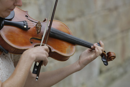 Violinist playing classical music with violin on the streetの写真素材