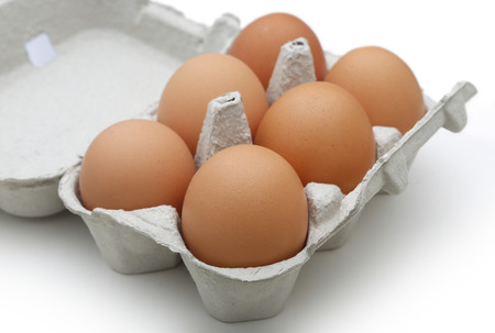 Eggs in the package on wooden tableの写真素材