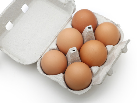 Eggs in the package on wooden tableの写真素材