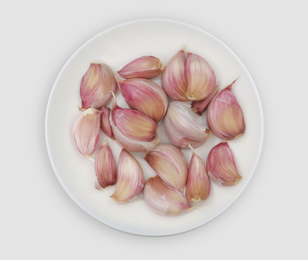 garlic on a white plate. Garlic contains vitamin B6 and vitamin Cの写真素材