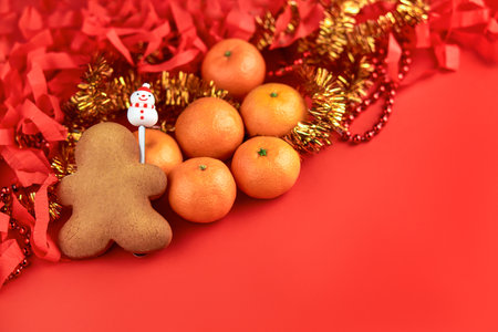 New Years composition. Christmas cookies, tangerines, holiday decoration on a red background. Copy space. Christmas backgroundの写真素材