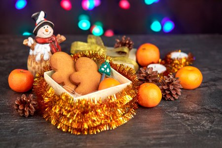 Gingerbread cookies in a gift box, Christmas toys around, tangerines, cones, candles. Festive...
