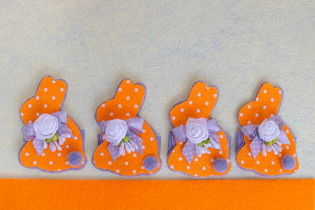 Easter decoration - Easter orange bunnies with ribbons on a light background. Easter pattern.の写真素材