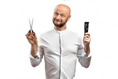 Funny hairdresser man. A bald European man hairdresser with a beard holding scissors and an electric...