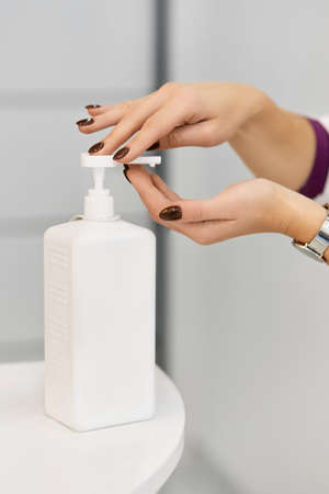 Hand sanitizer alcohol gel rub clean hands hygiene prevention of coronavirus virus outbreak. Woman using bottle of antibacterial sanitiser soap.の写真素材