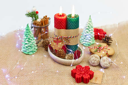 New Years, Christmas table decor with red-green candles, pine cones, spruce branches, garlands on a white background.の写真素材