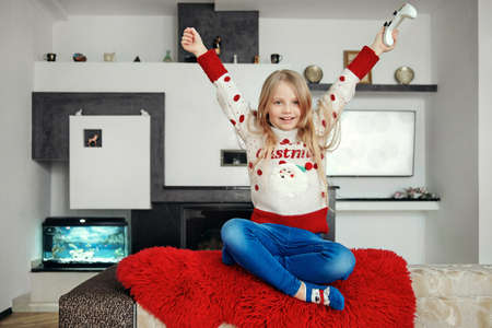 entertainment, home and internet - 6 years old blonde girl with joystick plays video games at homeの写真素材
