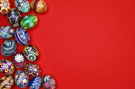 Red Easter card. Beautiful Easter multi-colored eggs on a red background, space for text.
