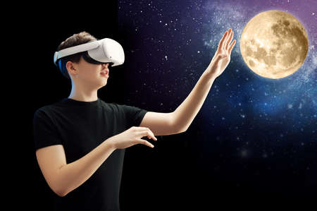 Guy in vr glasses plays and explores space, planets. Technology, online games, entertainment, education and the virtual world in 3D modeling.の写真素材