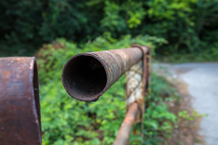 rusty railing pipe of a bridge in the countrysideの写真素材