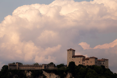 Historic Castle with Tower Overlooking Dramatic Sky and Lush Greeneryの写真素材
