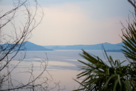 Scenic View of a Tranquil Lake Surrounded by Hills at Sunsetの写真素材