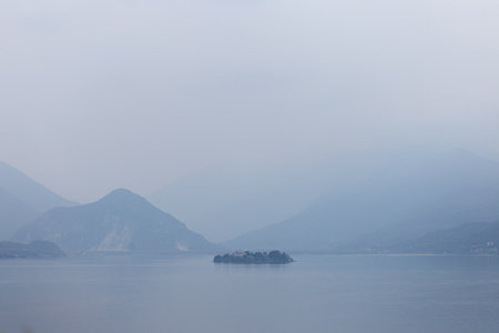 Serene Lake Landscape with Distant Mountains and Misty Atmosphereの写真素材