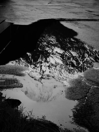 Snowy mountain reflection on a puddle
