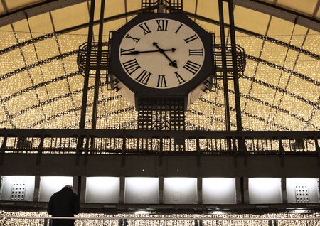 Ceiling, a big clock and christmas lights in a train stationの写真素材