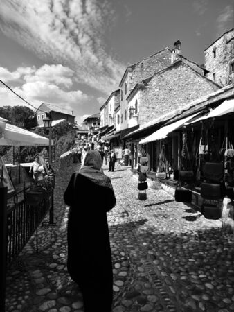 Woman walking in a market in the street in Mostar's old town in Bosniaの写真素材