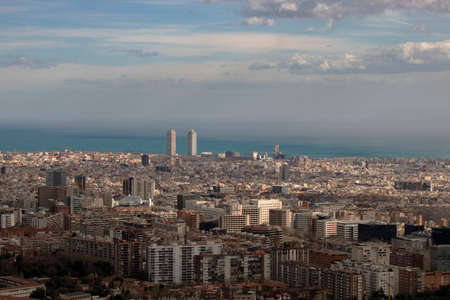 Barcelona cityscape and Mediterranean sea viewed from above under a cloudy skyの写真素材