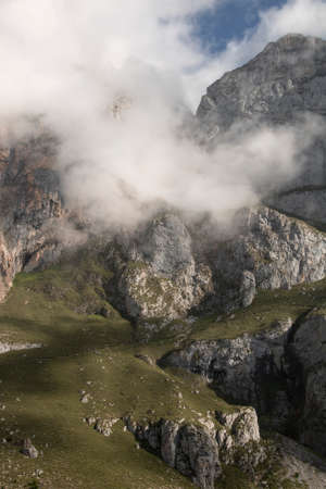 Foggy landscape showing a rocky mountain in Fuente De in Picos de Europa in Spainの写真素材