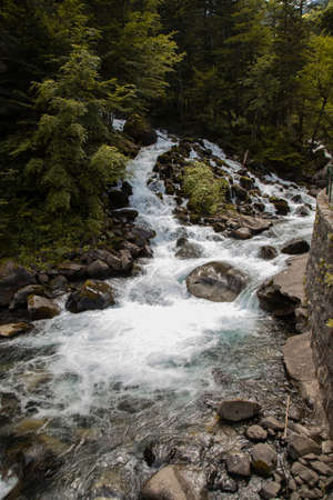 Landscape showing some big rocks and water flowing in a big waterfall called Uelhs deth Joeu in Cataloniaの写真素材