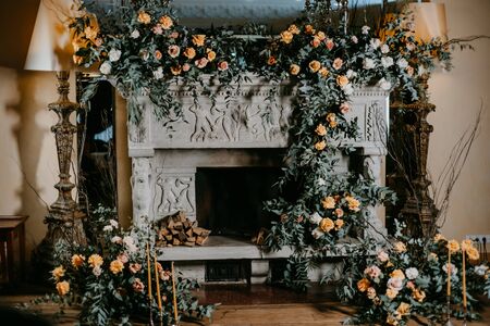 Decorated with roses and other flowers fireplace without fireの写真素材