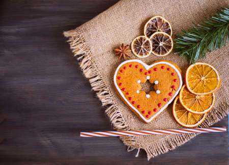 Christmas tasty cookies lie on a napkin on wooden background. Around the cookies lies dried orange and a spruce branch.の写真素材