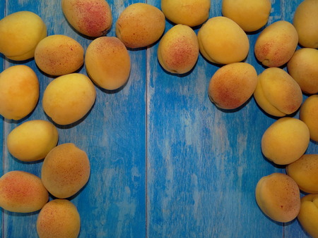 apricots on blue wooden boardsの写真素材