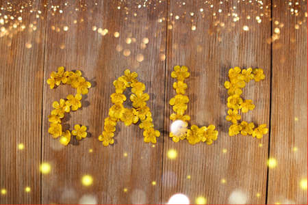 beautiful inscription sale, laid out of buttercup flowers on a wooden backgroundの写真素材