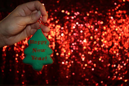 beautiful Christmas tree is lying on his hands, on a shiny backgroundの写真素材