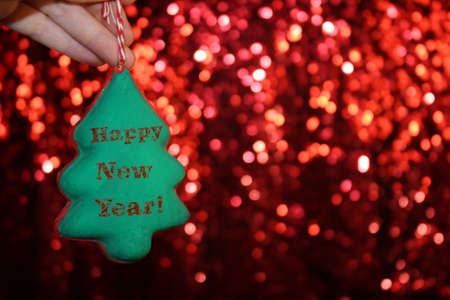 beautiful Christmas tree is lying on his hands, on a shiny backgroundの写真素材