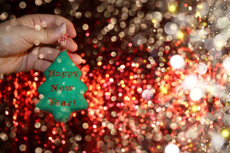 beautiful Christmas tree is lying on his hands, on a shiny backgroundの写真素材